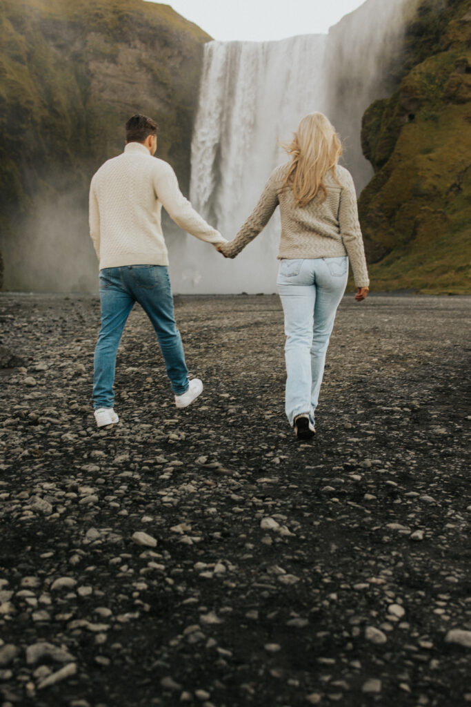 walking in front of skogafoss waterfall