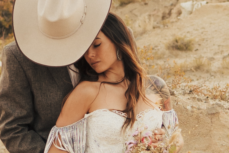 stunning bride wearing a white dress and the groom wearing a cowboy hat