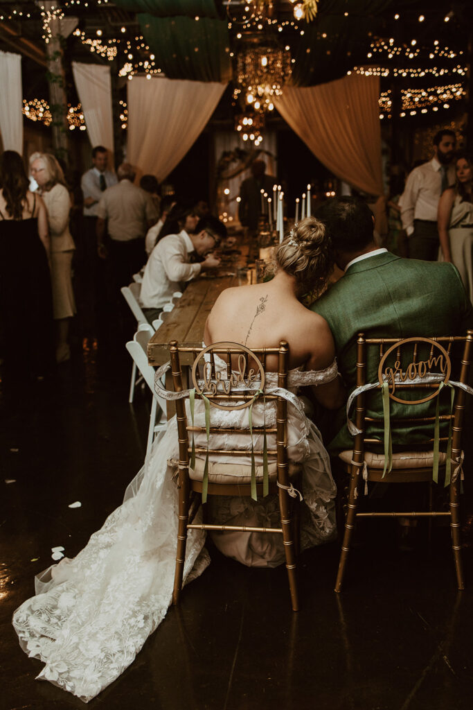 bride and groom sitting during their wedding reception