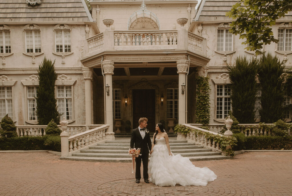 couple posing in front of their wedding venue in utah
