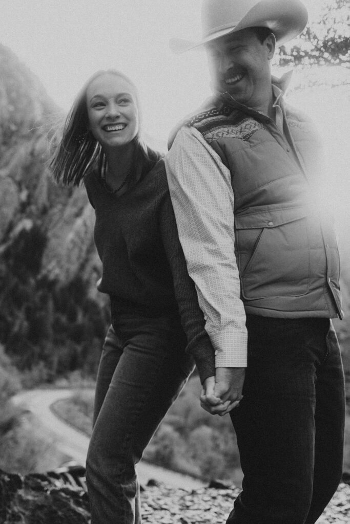 stunning couple standing back to back holding hands
