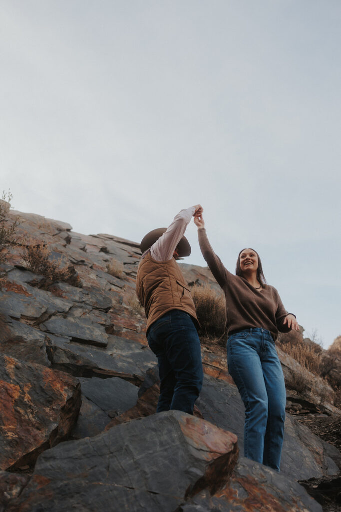 adventurous couple dancing at storm mountain in Utah during their engagement session