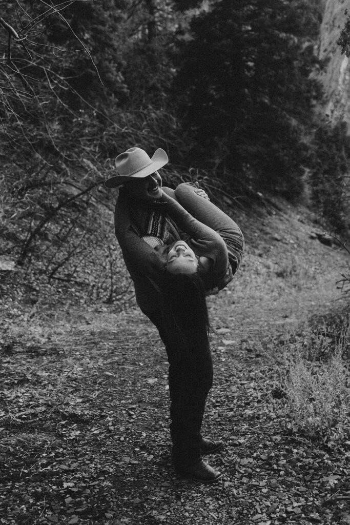 black and white photo of the fiance carrying her fiance during their photoshoot