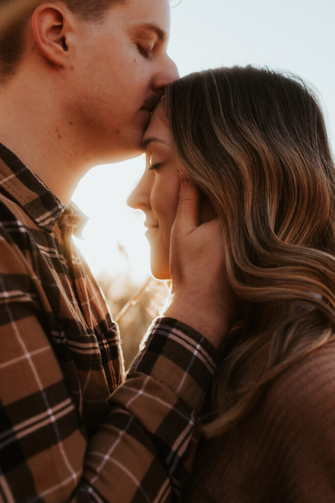 fiance kissing his fiance on the forehead 