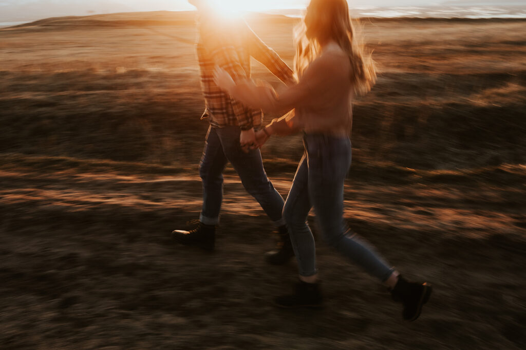 couple running holding hands during their engagement photoshoot 