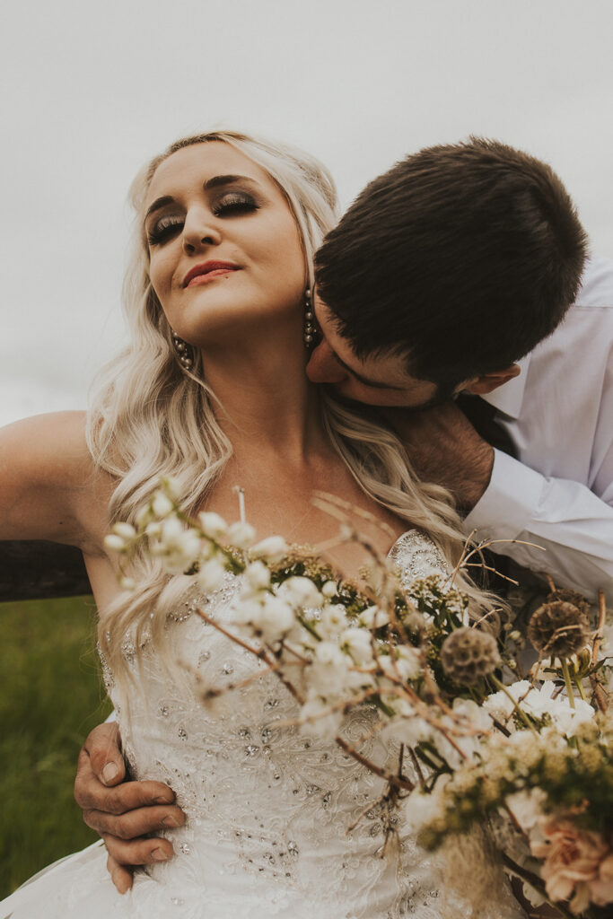 groom kissing the bride on the neck