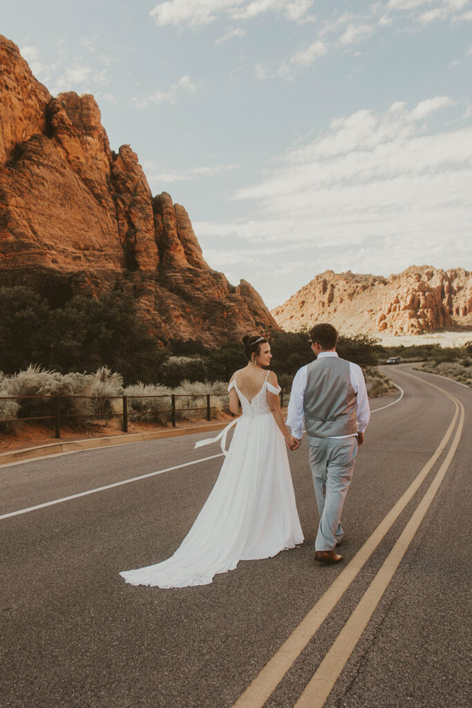 bride and groom holding hands looking at each other 