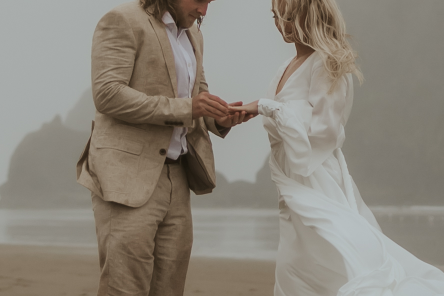 bride and groom exchanging rings at their cinematic beach elopement