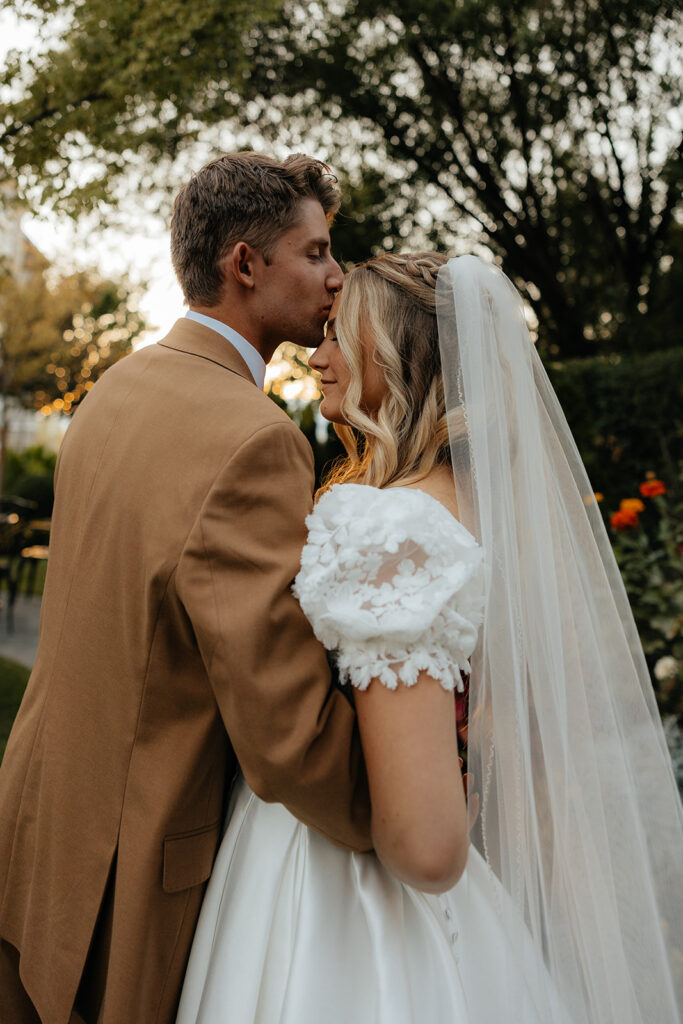 groom kissing the bride on the forehead 
