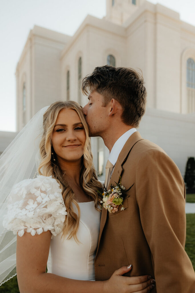 groom kissing the bride on the forehead
