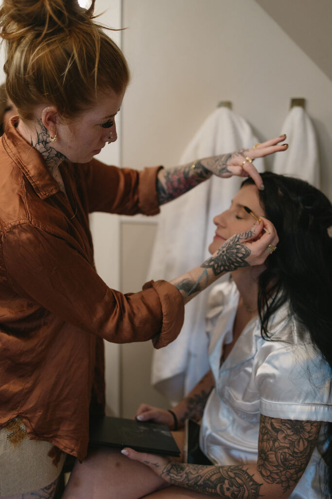 bride getting her makeup done before the ceremony
