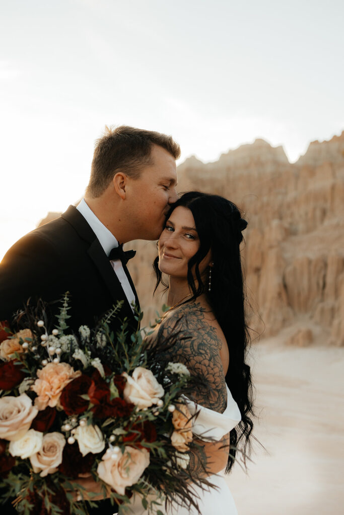 groom kissing the bride on the forehead 