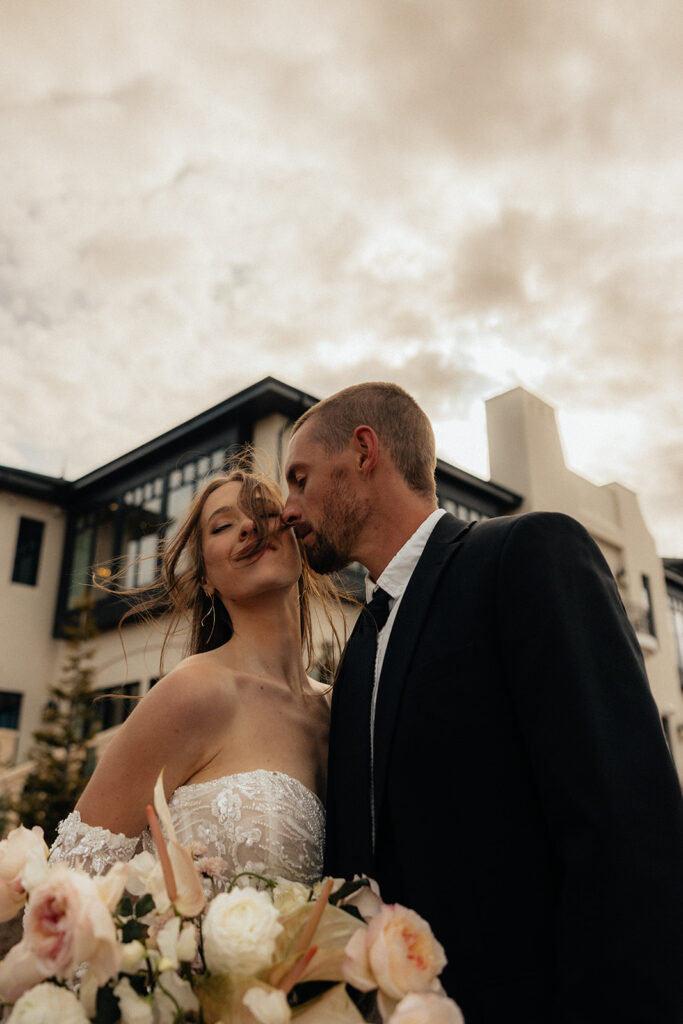 groom kissing the bride on the cheek