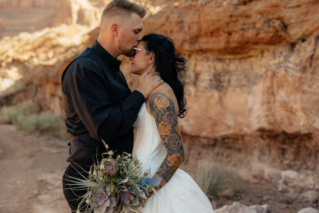 groom kissing the bride on the forehead