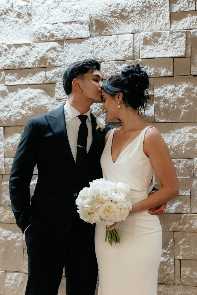 groom kissing the bride on the forehead